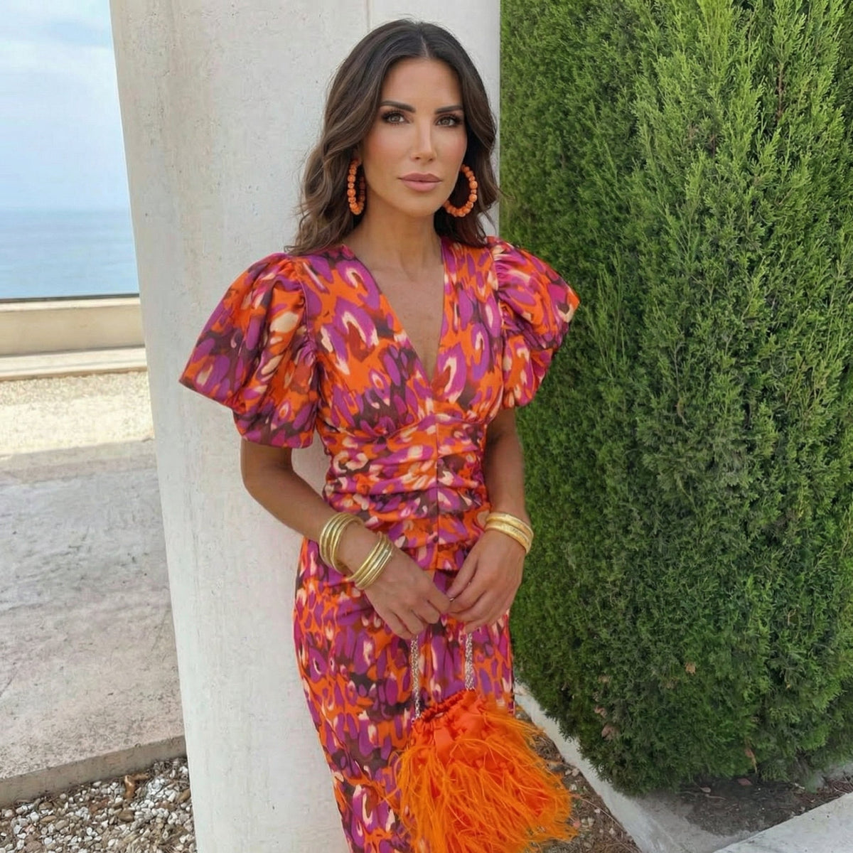 Robe d’été orange à motifs violets, décolleté croisé, manches bouffantes, ceinture.