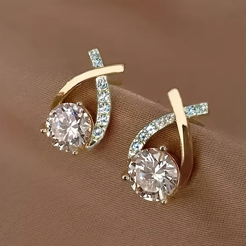 Puces d’oreilles croix dorée serties de zirconium transparent, vue de face