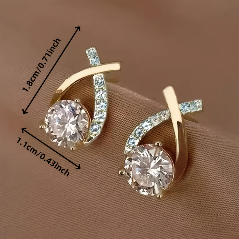 Puces d’oreilles croix dorée serties de zirconium transparent, vue rapprochée