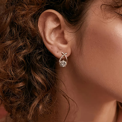 Puces d’oreilles croix dorée et zirconium transparent, portées avec cheveux