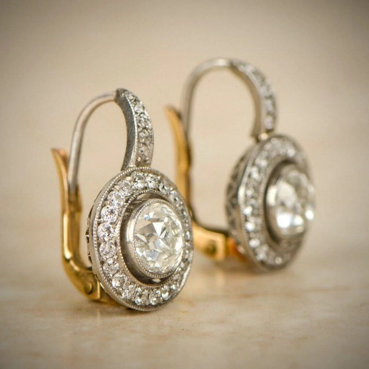 Boucles d’oreilles vintage : cristal clair ovale, monture argentée et accents dorés.