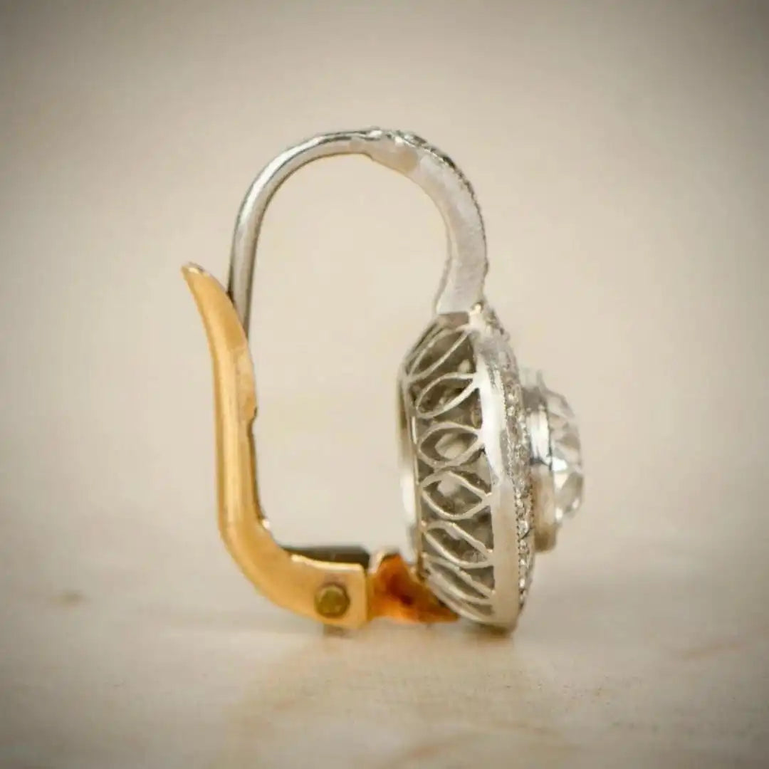Boucles d’oreilles vintage : cristal clair ovale, monture argentée, tige et fermoir dorés.