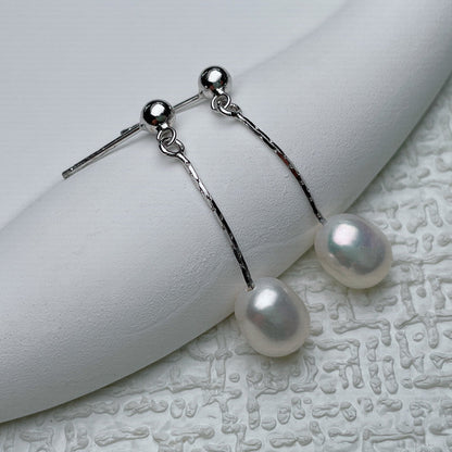 Boucles d’oreilles argentées à perle blanche pendante, chaînes et tiges.