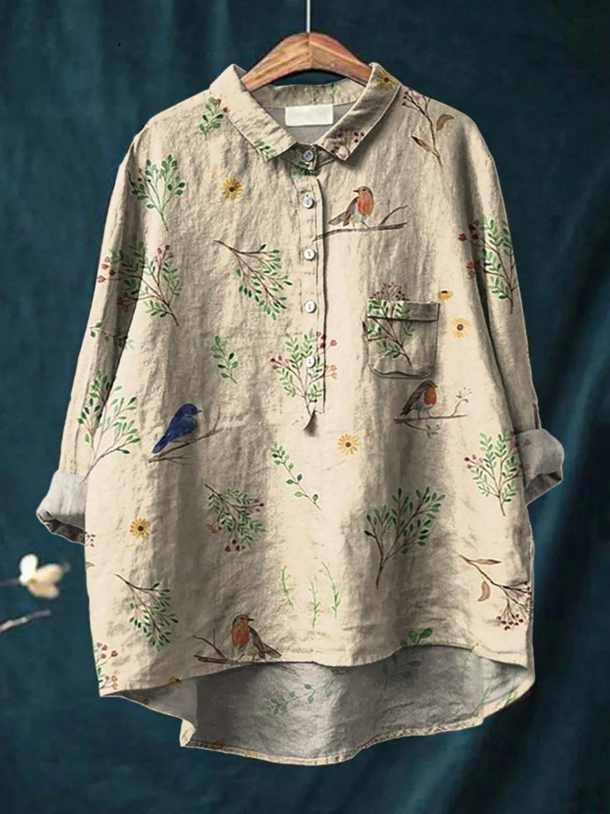 Chemise ample beige à motif oiseaux et fleurs, col boutonné, poche poitrine, manches longues.