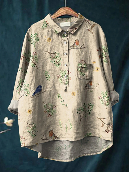 Chemise ample beige à motif oiseaux et fleurs, col boutonné, poche poitrine, manches longues.