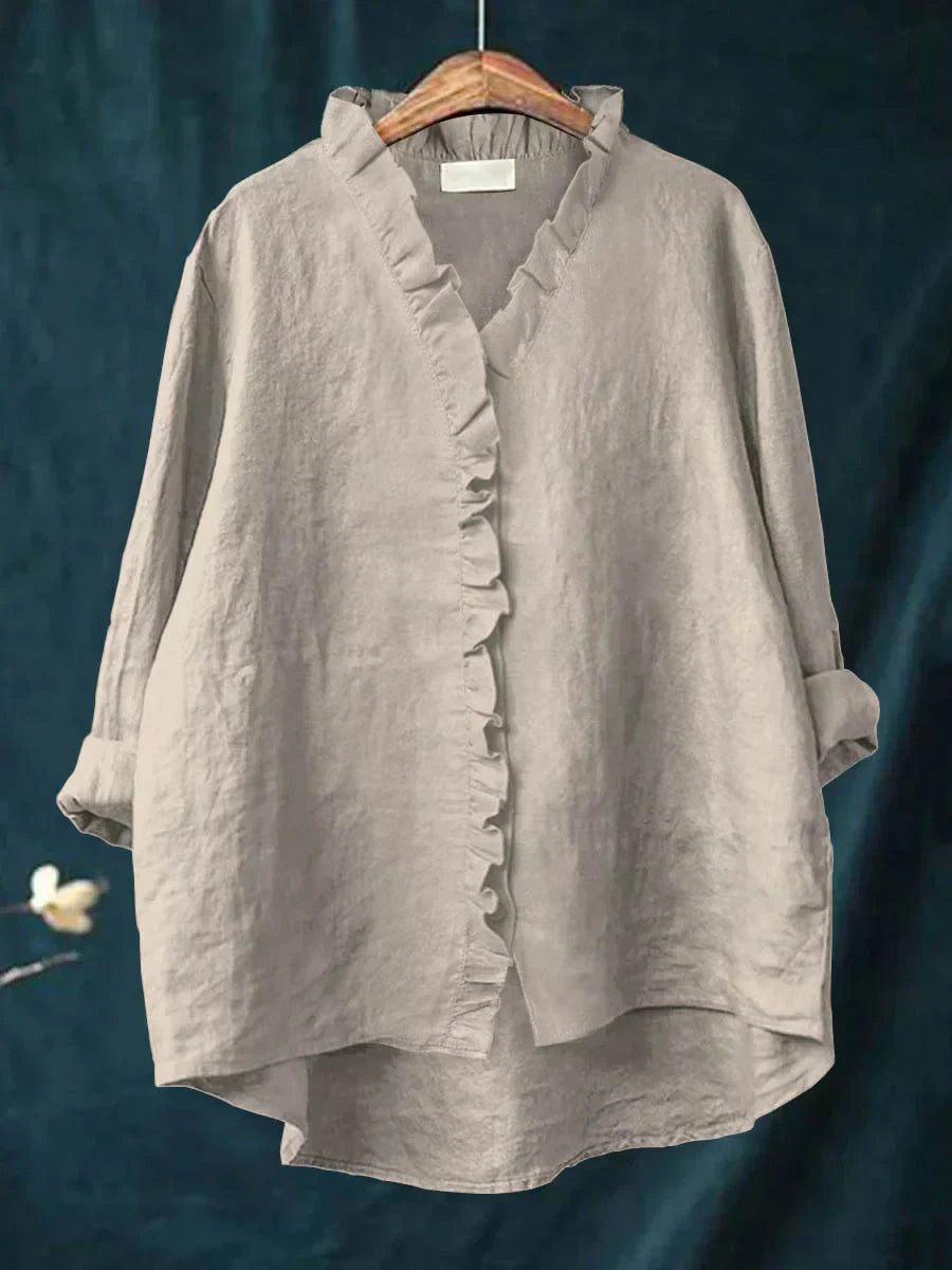 Blouse légère gris clair à col V, volants sur l’avant et boutons, manches amples