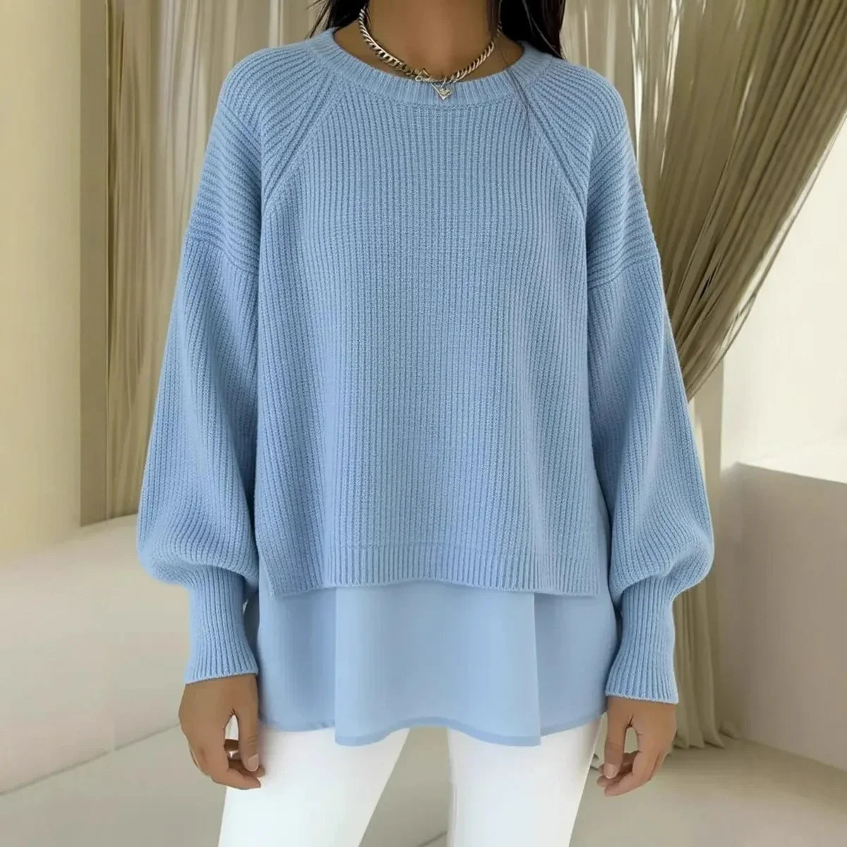 Pull en tricot bleu clair, col rond côtelé, manches bouffantes, bas superposé