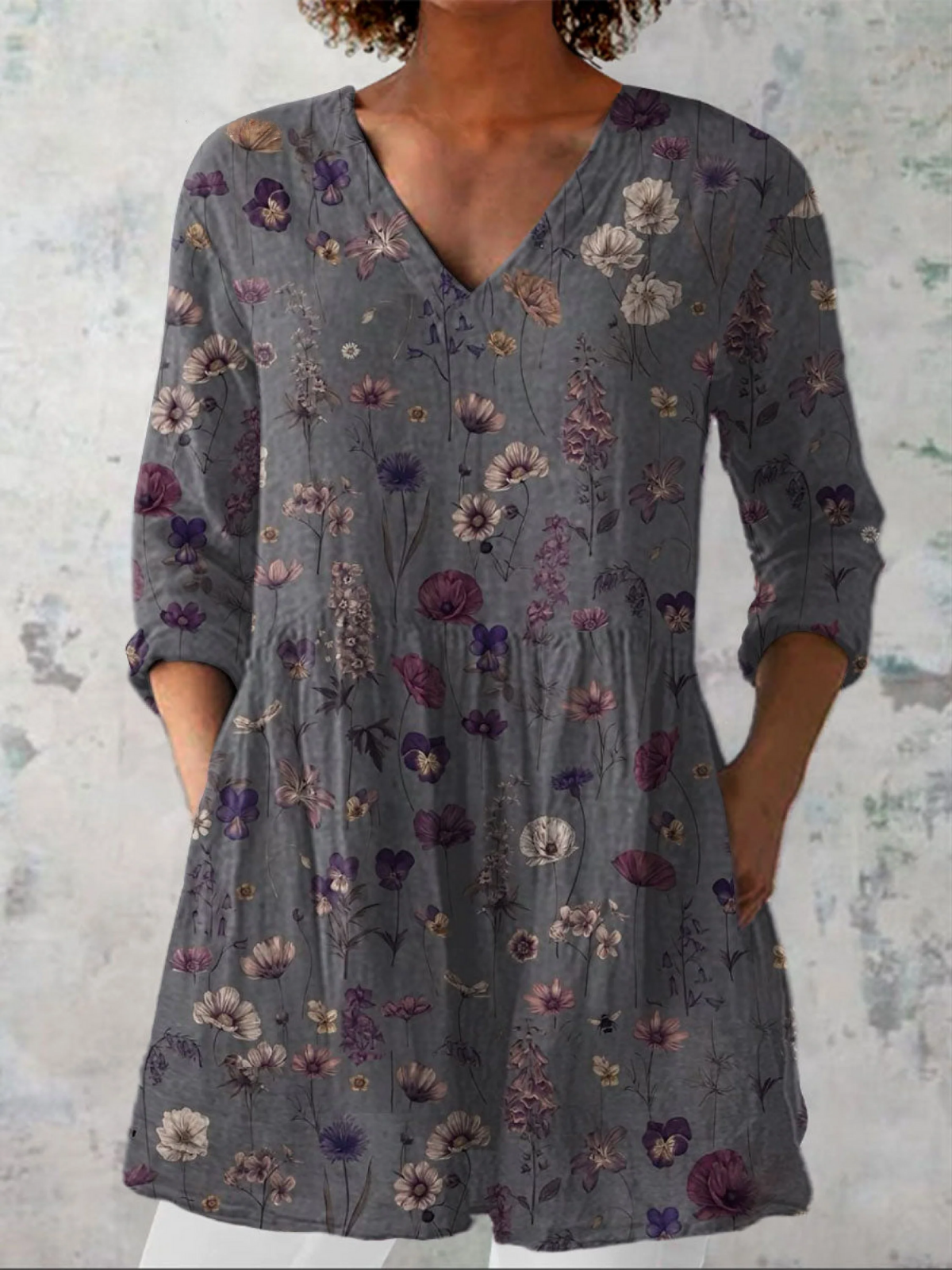 Blouse grise à col V, manches longues amples, imprimé floral violet et rose.