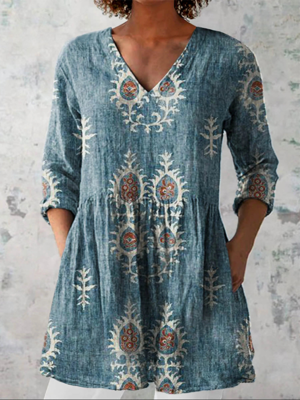 Blouse longue à col en V bleu chiné, broderies florales blanches et rouges sur l’avant