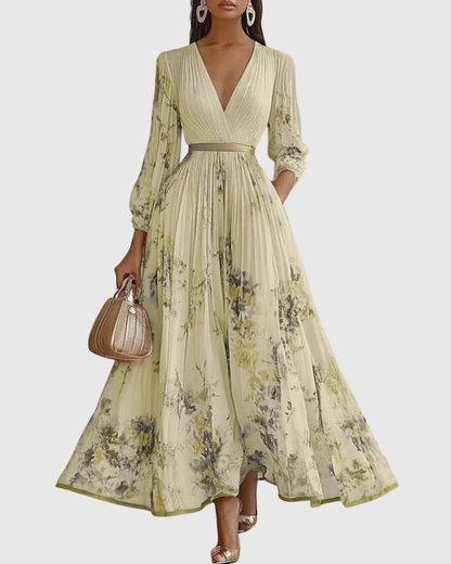 Robe longue plissée manches longues, encolure V, imprimé floral vert sur fond clair.