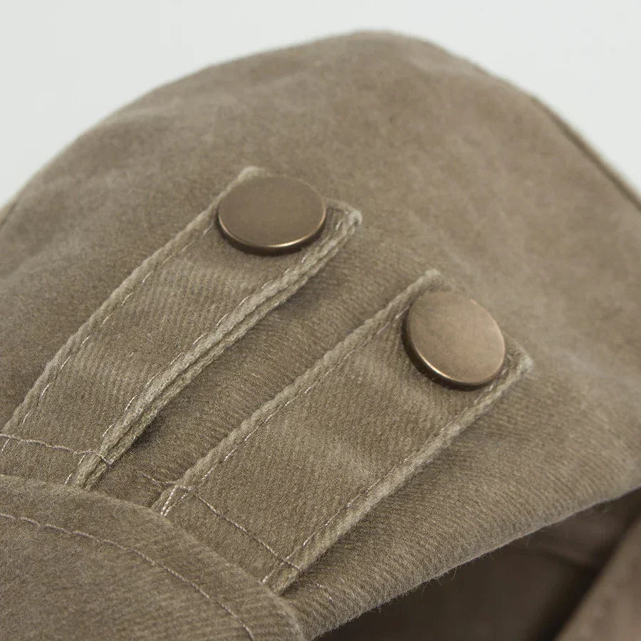 Casquette vintage homme kaki, gros plan sur tissu et deux boutons métalliques.