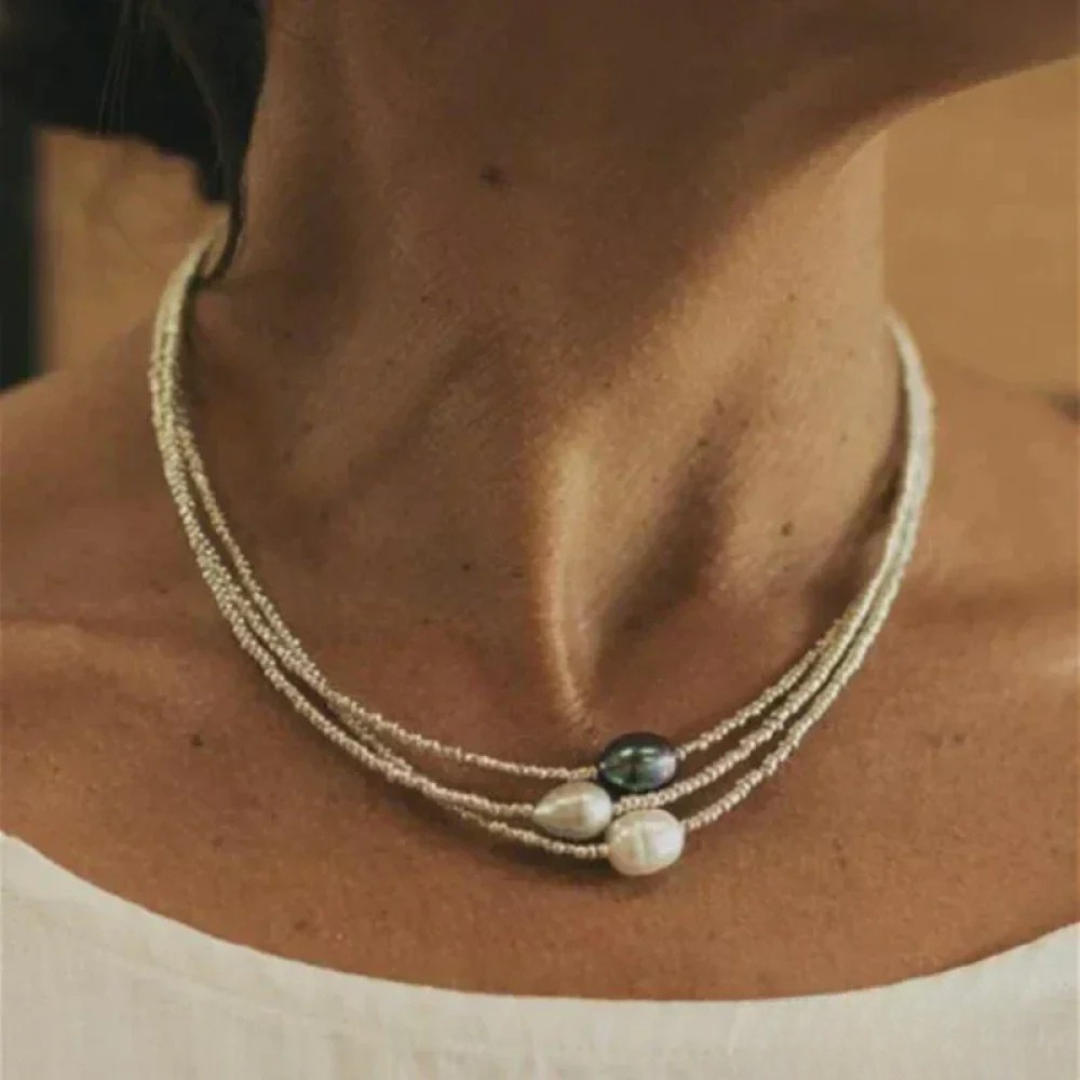 Collier ancien en perles à ras du cou, double rang, perle noire et blanche centrale.