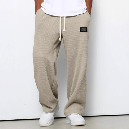 Pantalon pour hommes à coupe confortable beige kaki, taille à cordon, devant fendu, étiquette.