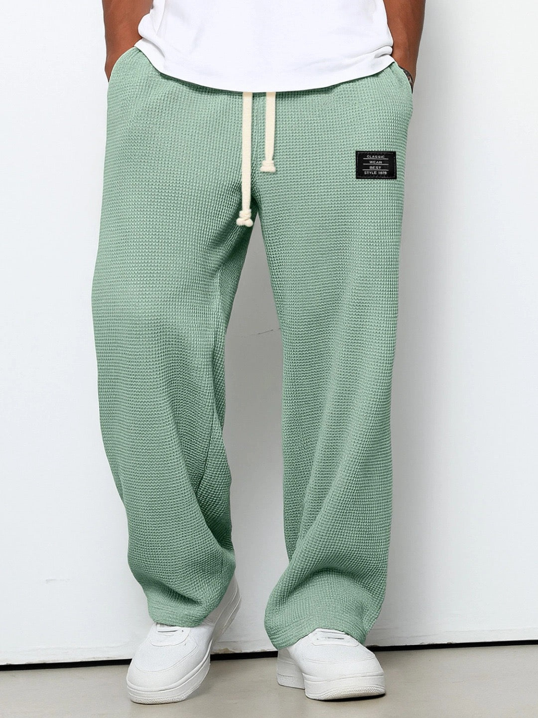 Pantalon pour hommes à coupe confortable vert, taille à cordon, devant fendu, étiquette.