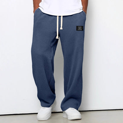 Pantalon pour hommes à coupe confortable bleu, taille à cordon, devant fendu, étiquette.