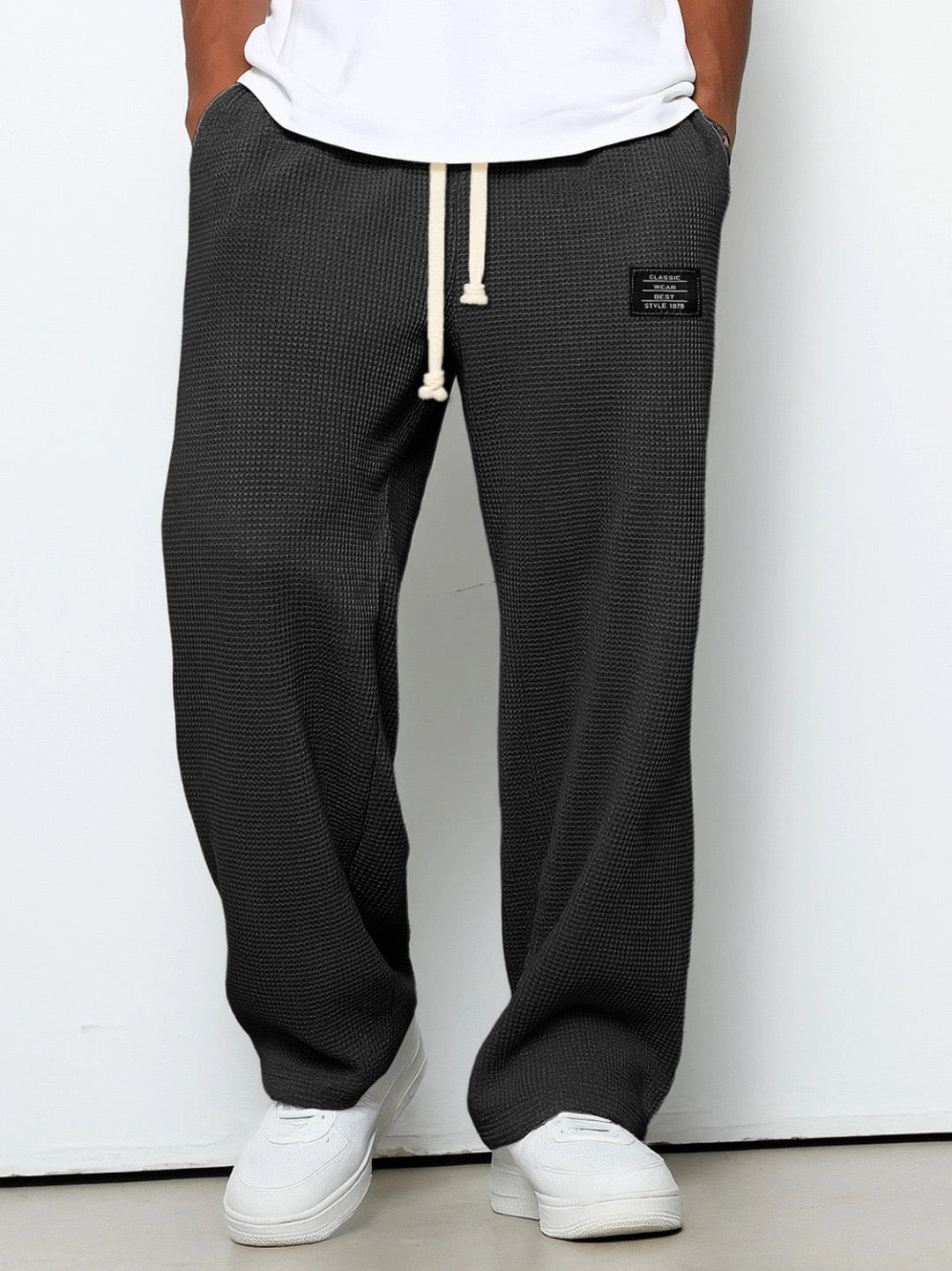 Pantalon pour hommes à coupe confortable noir, taille à cordon, devant fendu, étiquette.