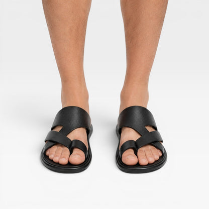 Sandales en cuir noires à enfiler avec boucle d’orteil, portées pieds nus