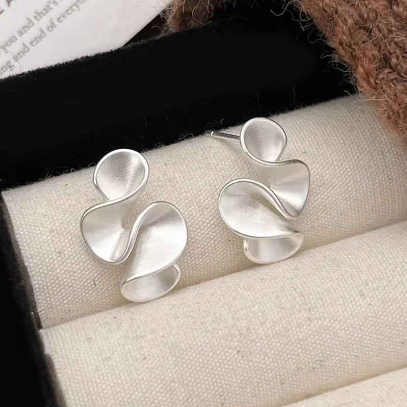 Boucles d’oreilles argentées en forme de trois pétales ajourés, finition lisse