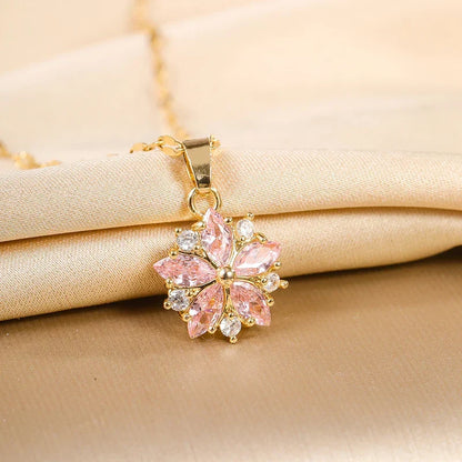 Pendentif fleur rose en strass sur collier doré, fermoir et chaîne visibles