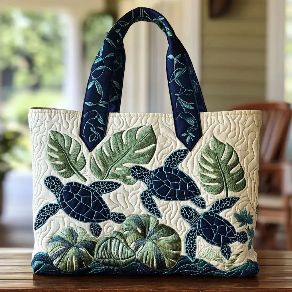 Sac cabas ivoire à motif feuilles et tortues bleu marine, anses en tissu à feuillages.