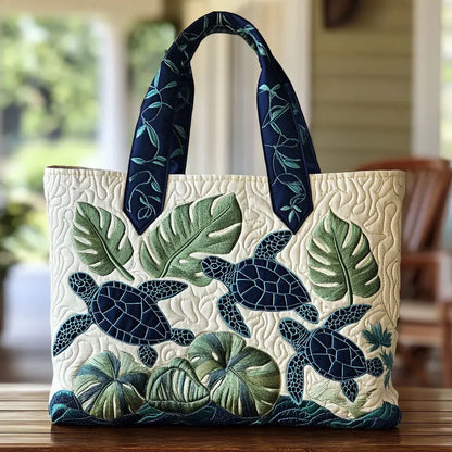 Sac cabas ivoire à motif feuilles et tortues bleu marine, anses en tissu à feuillages.