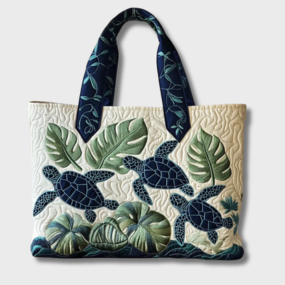 Sac cabas ivoire rectangulaire avec motif feuillages et tortues bleu/vert, anses assorties.