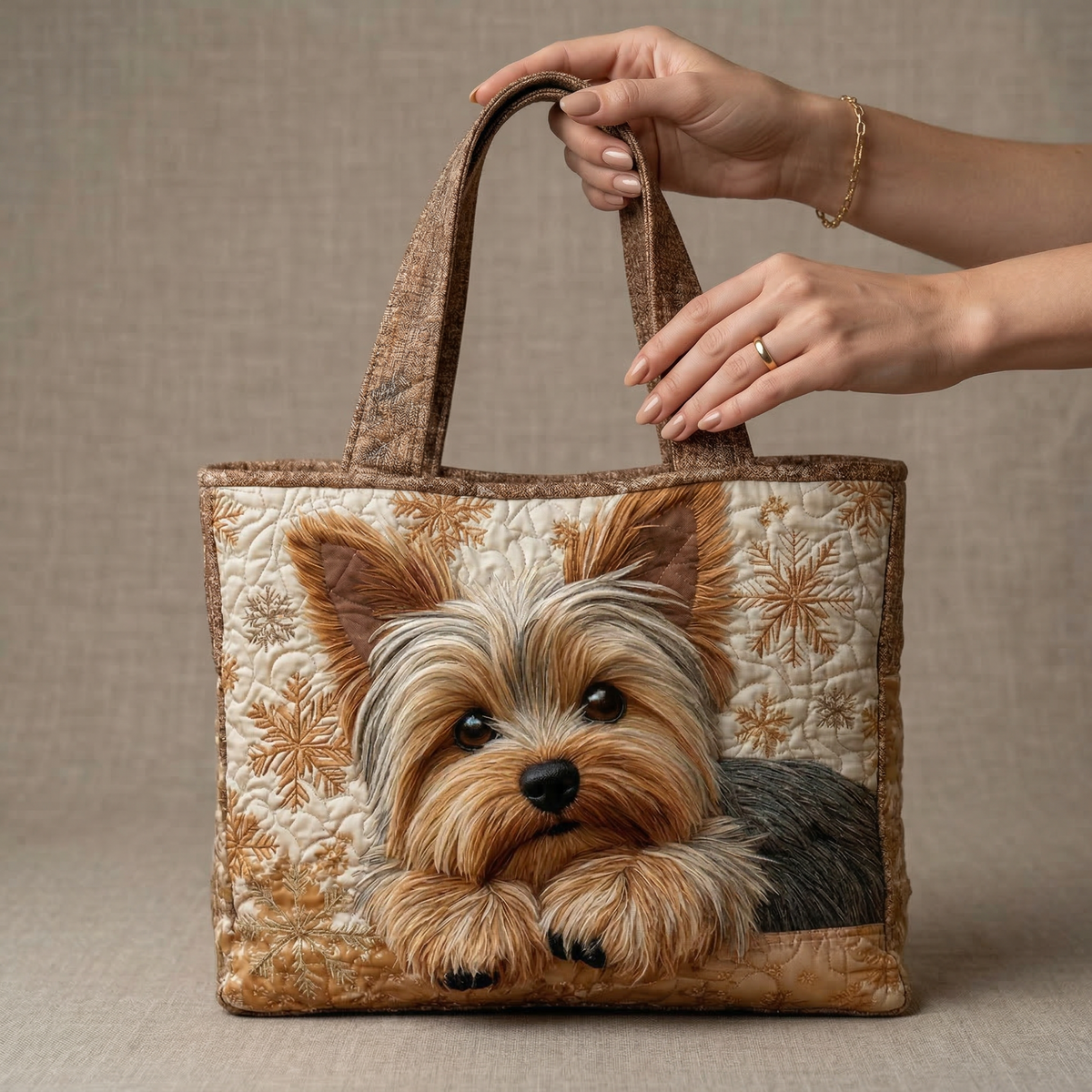 Sac bourse matelassé beige à motifs, tête de chien brodée, tenu par la poignée