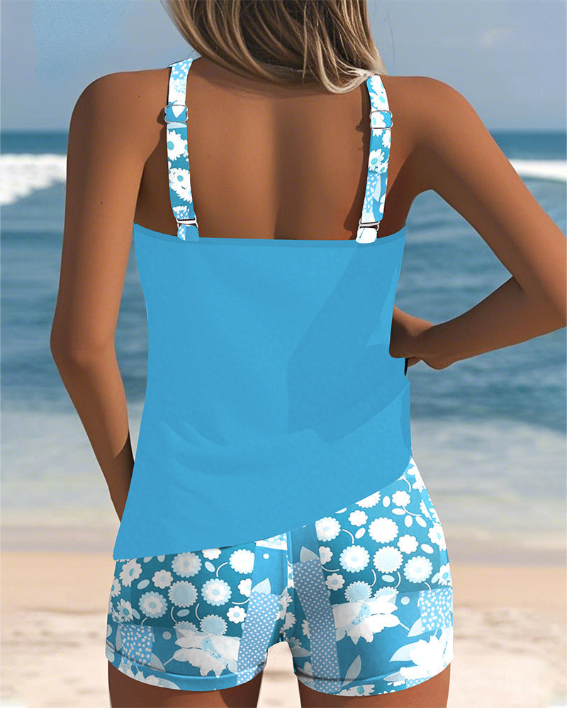 Ensemble tankini bleu clair à bretelles, short imprimé fleurs bleues et blanches.