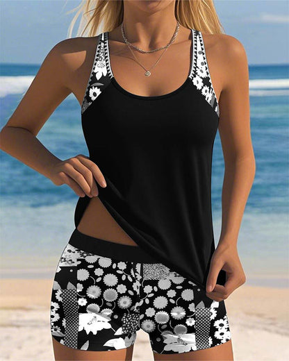 Ensemble tankini noir, débardeur à bretelles et short imprimé fleurs blanches.