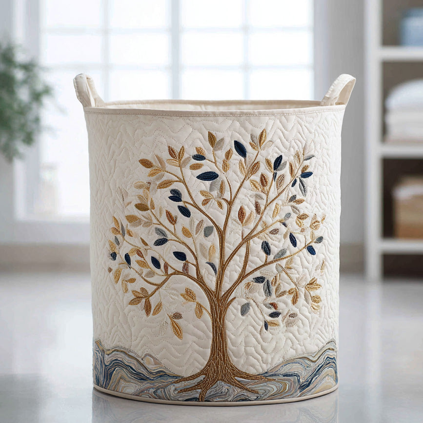 Panier à linge en tissu beige avec broderie arbre et motifs feuilles bleues, poignées.