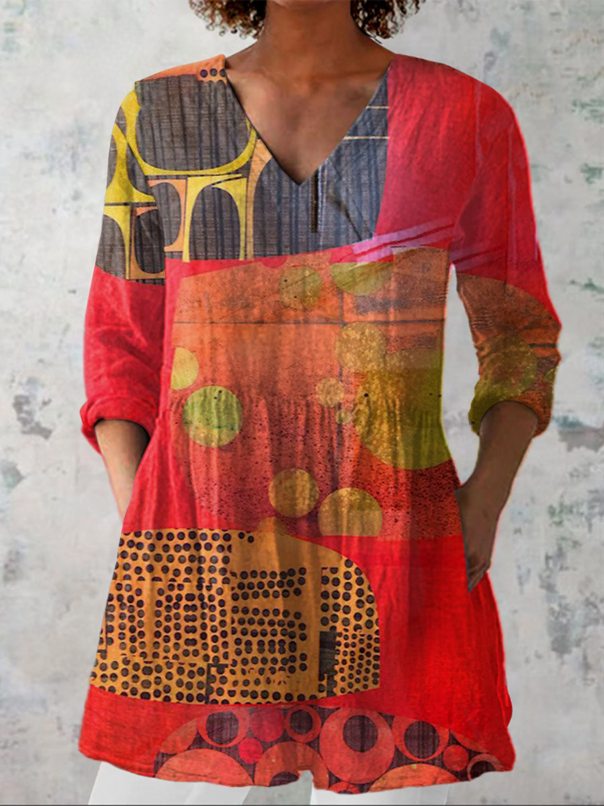 Blouse longue rouge à décolleté en V, manches trois-quarts, imprimé abstrait.