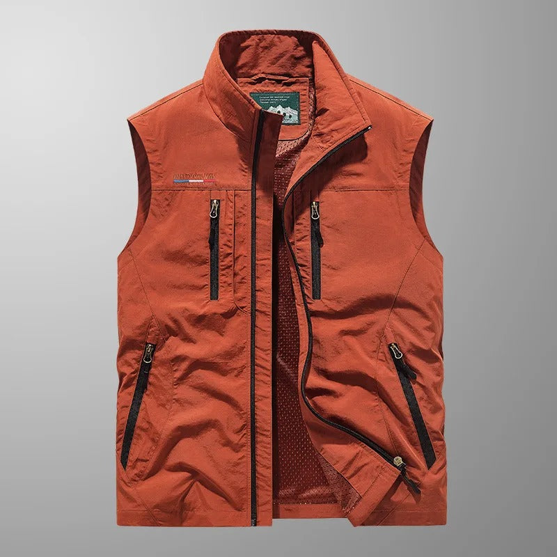 Gilet sans manches rouge brique, fermeture zippée et poches zippées sur l’avant.