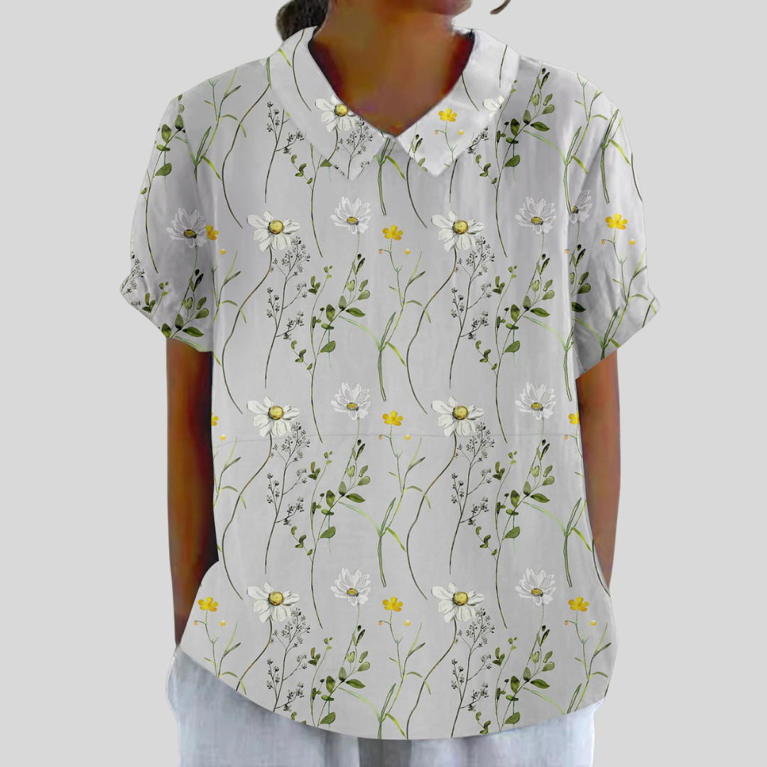 Blouse blanche manches courtes, col boutonné, motif marguerites et fleurs jaunes.