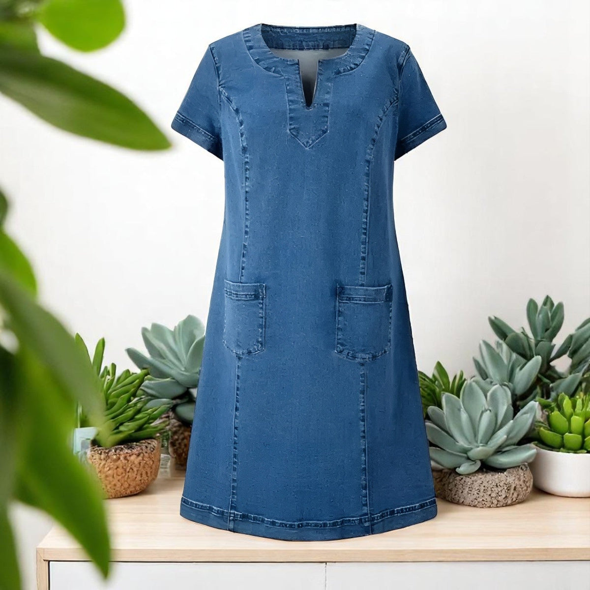 Robe en denim bleu avec encolure V, manches courtes et deux poches avant