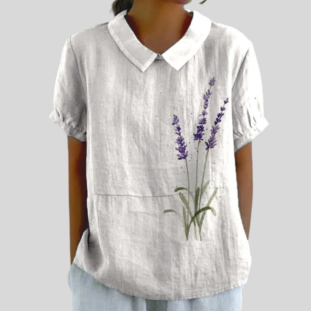 Blouse en lin blanc à col et manches courtes, imprimé fleurs violettes sur le devant.