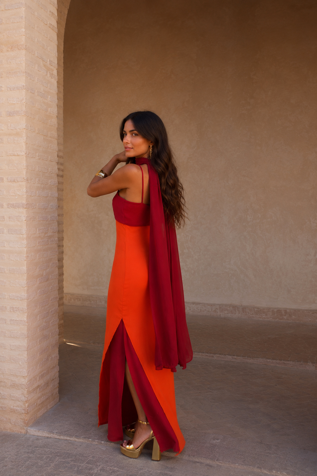 Robe longue orange avec fente, bretelles fines, nœud bordeaux et voile au dos.