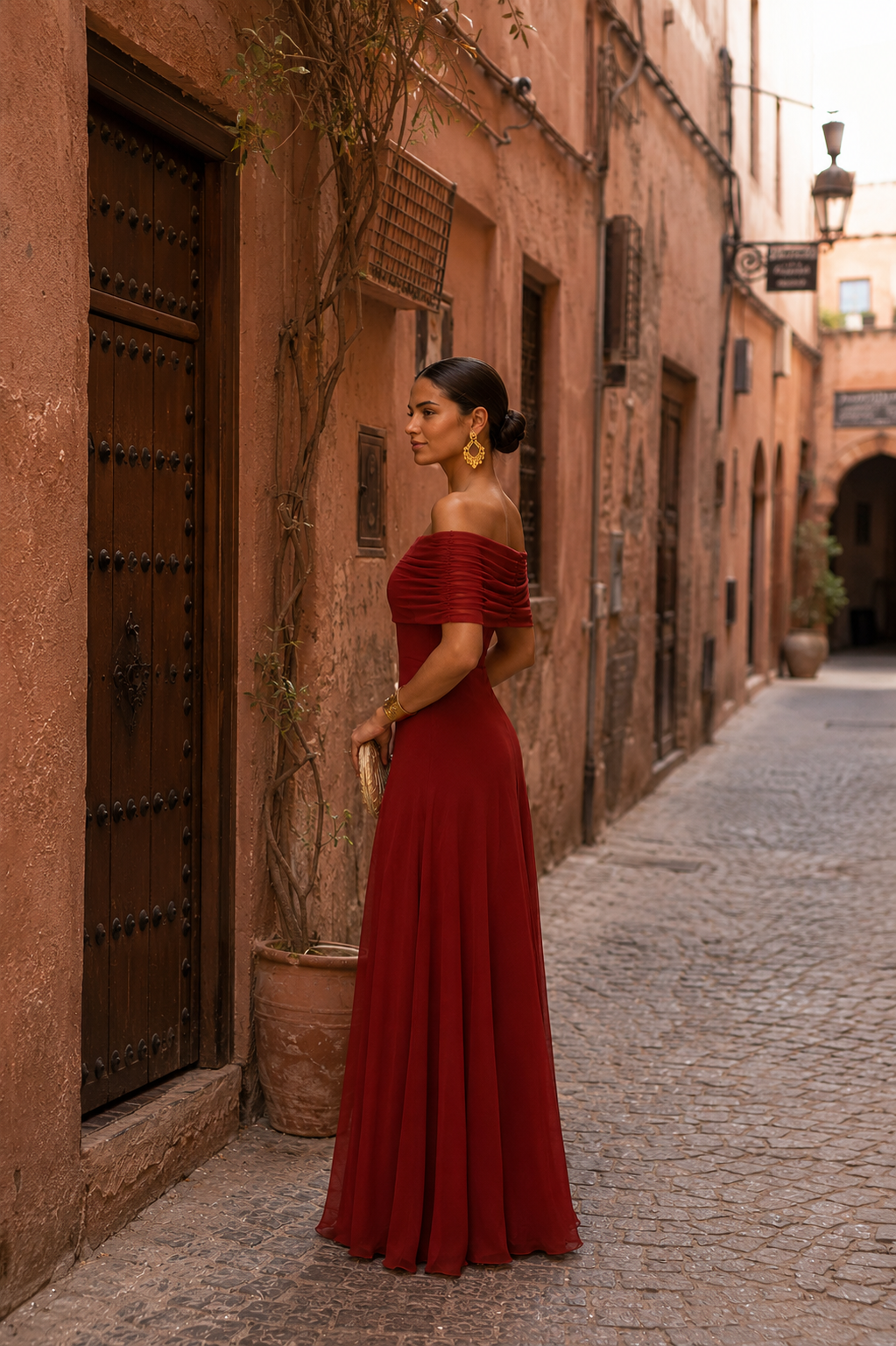 Robe longue rouge bordeaux à épaules dénudées, dos nu partiel, buste froncé.