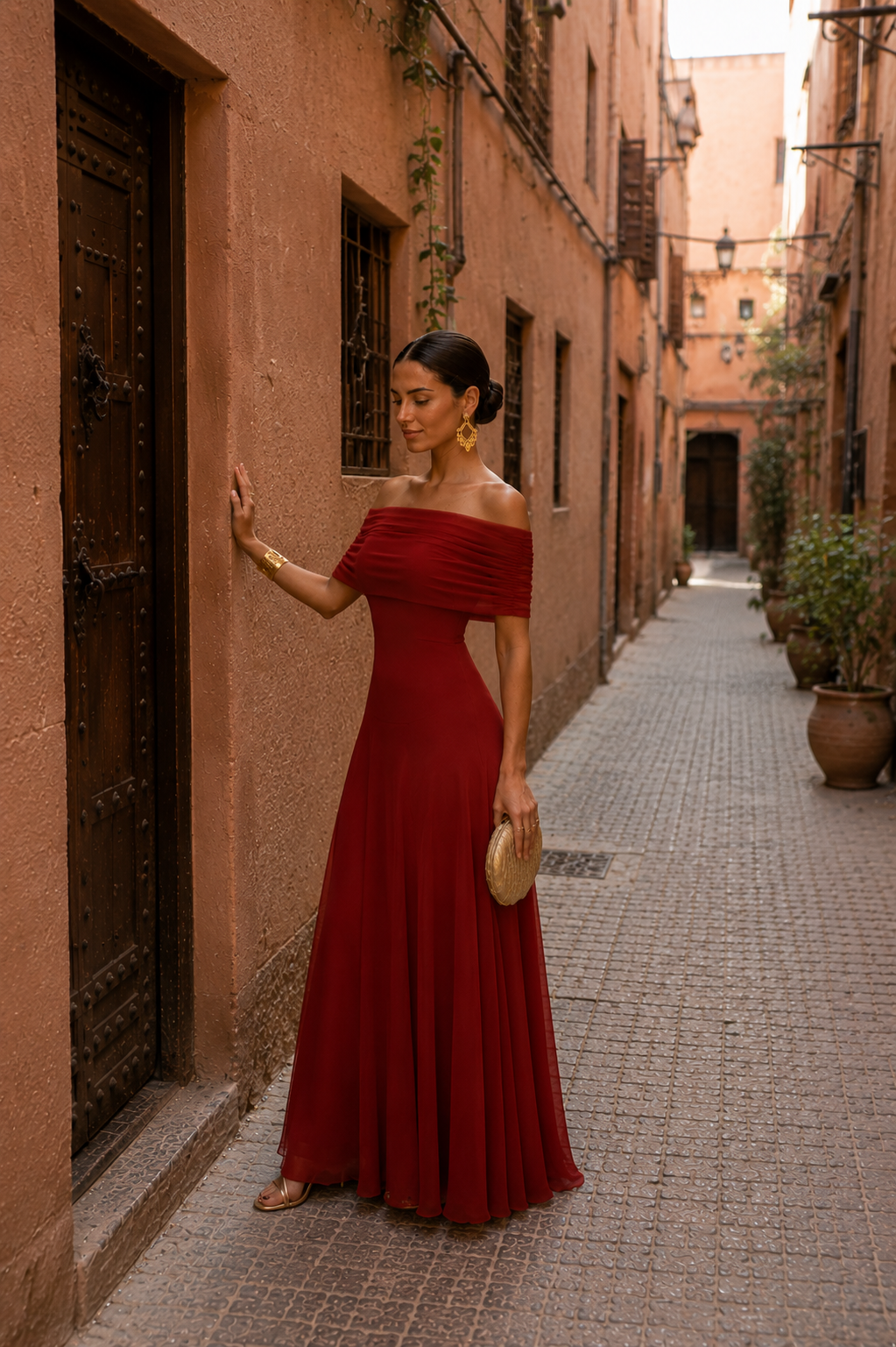 Robe longue rouge bordeaux bardot, épaules dénudées, buste froncé et jupe évasée.