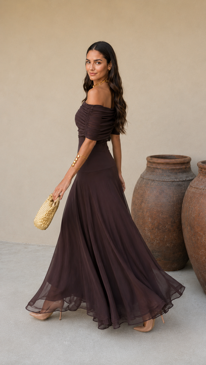 Robe longue marron foncé drapée, bretelle asymétrique, jupe ample avec léger effet volant.