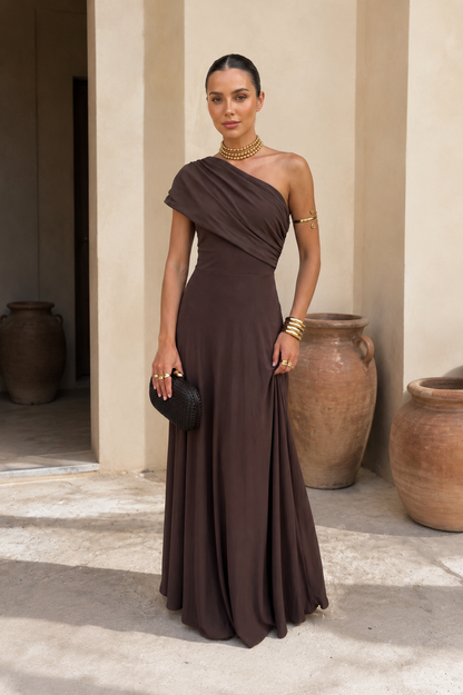 Robe longue marron foncé asymétrique, drapée sur l’épaule, jupe fluide.