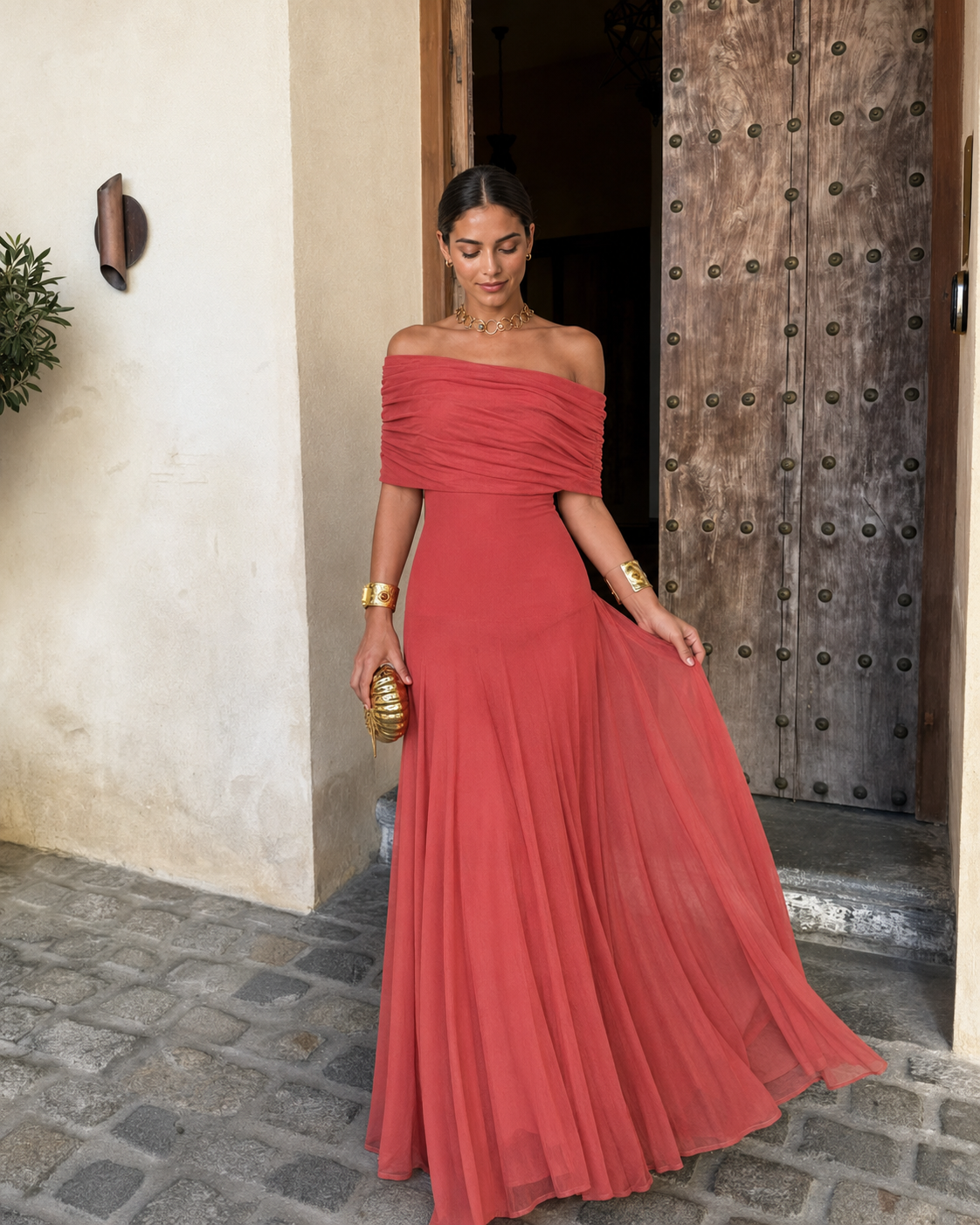 Robe longue terracotta à épaules dénudées, buste froncé, jupe plissée en évasement.