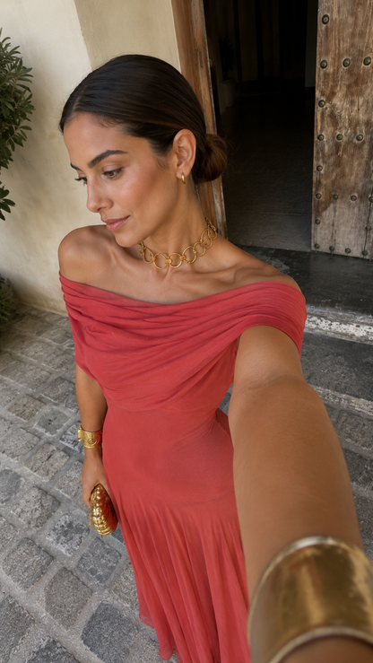 Robe terracotta à épaules dénudées, buste drapé avec fronces, tissu léger plissé.