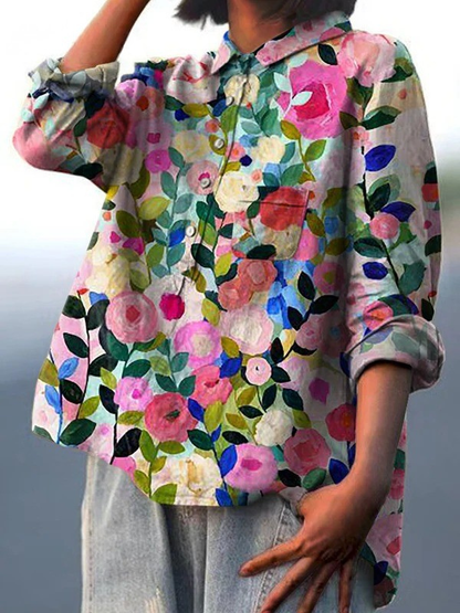 Chemise à fleurs multicolores, manches longues et encolure à volants, boutonnage.