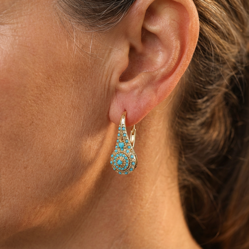 Boucles d’oreilles créoles dorées turquoise sur l’oreille, motif floral émaillé