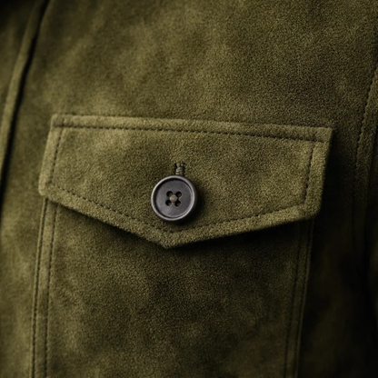 Veste en daim vert olive, poche poitrine à rabat et bouton rond visible.
