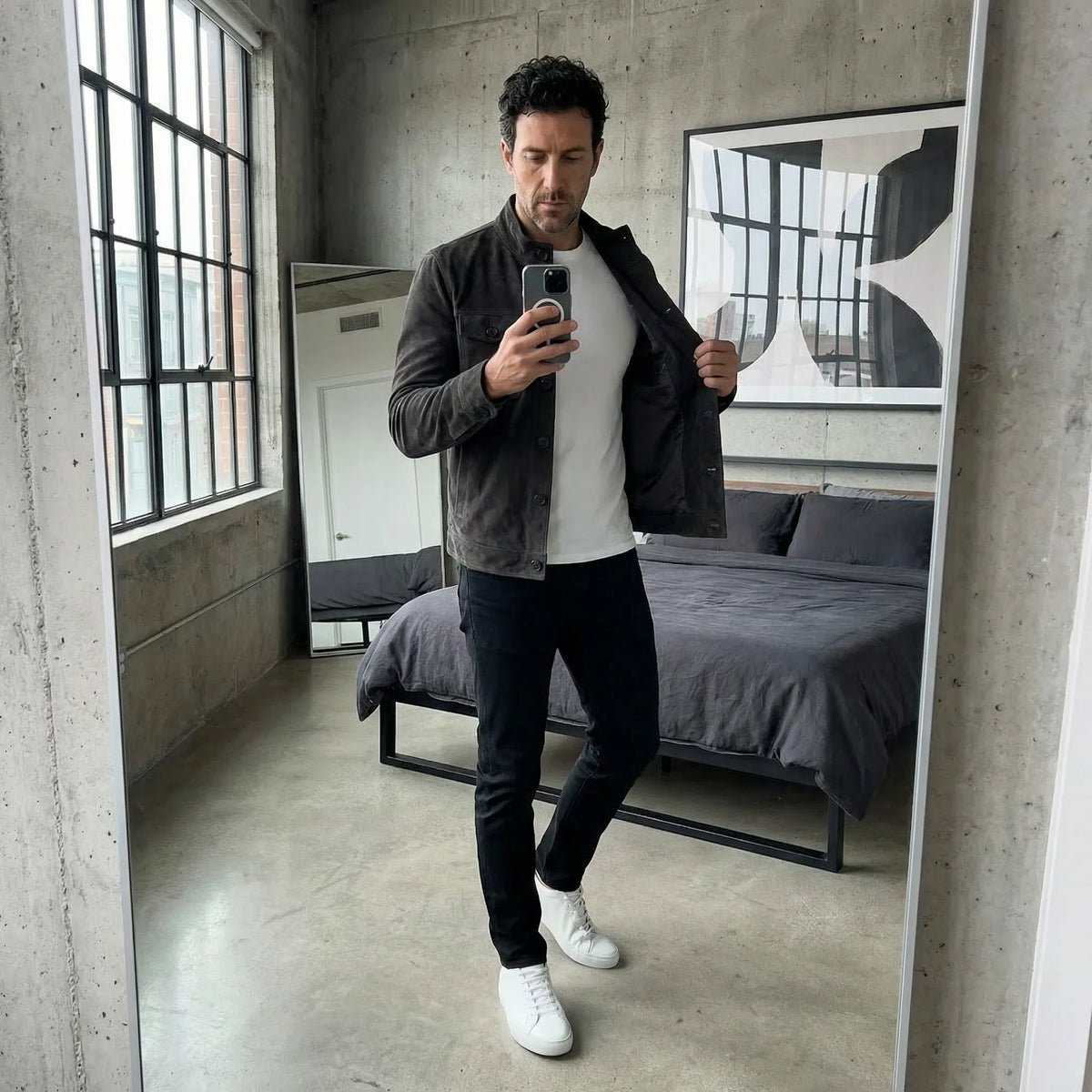 Veste en daim noire portée, patte boutonnée et poches poitrine visibles.