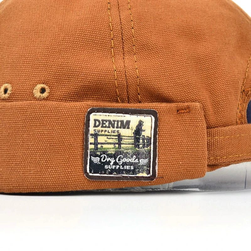 Gros plan sur patch « Denim » d’une casquette orange pour animal de compagnie.