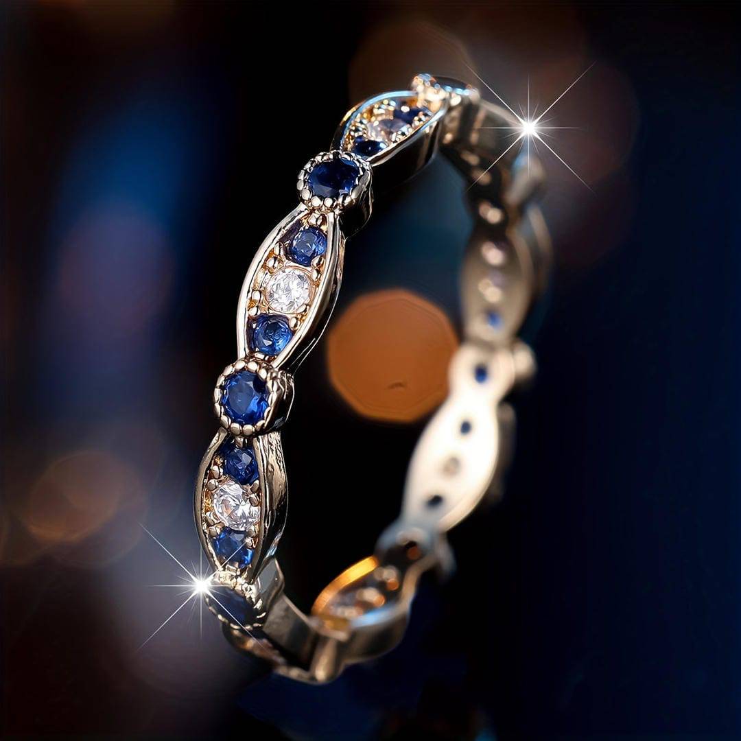 Bague anneau dorée, saphirs bleus et pierres claires en monture sertie sur le côté