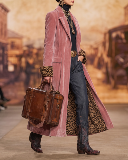 Manteau long rose poudré, porté de profil, col revers et fente au bas.