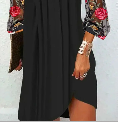 Robe noire, ourlet fendu et décolleté V, manches imprimées à roses rouges.